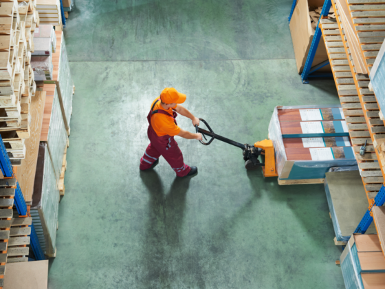 Overhead view of worker in warehouse moving a pallet of goods