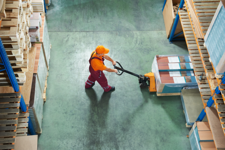 Overhead view of worker in warehouse moving a pallet of goods