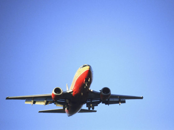 View looking up at large commercial airplane taking off