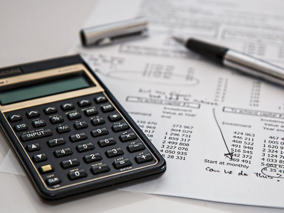 Close up of a calculator and pen on top of a document