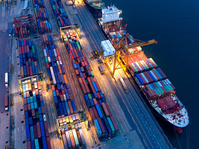 Aerial view of a working dock and cargo ship begin loaded by a crane