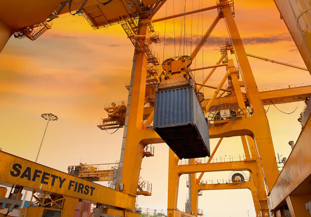 Looking up at a large container crane moving a container