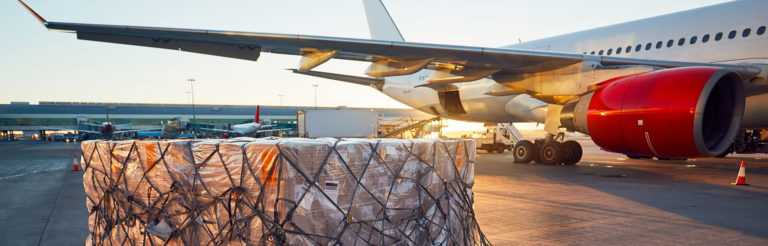 Cargo waiting to be loaded on cargo plane in the background