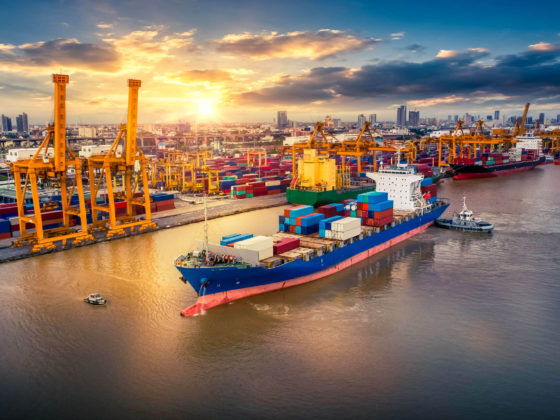 Container ship preparing to dock in port during sunrise