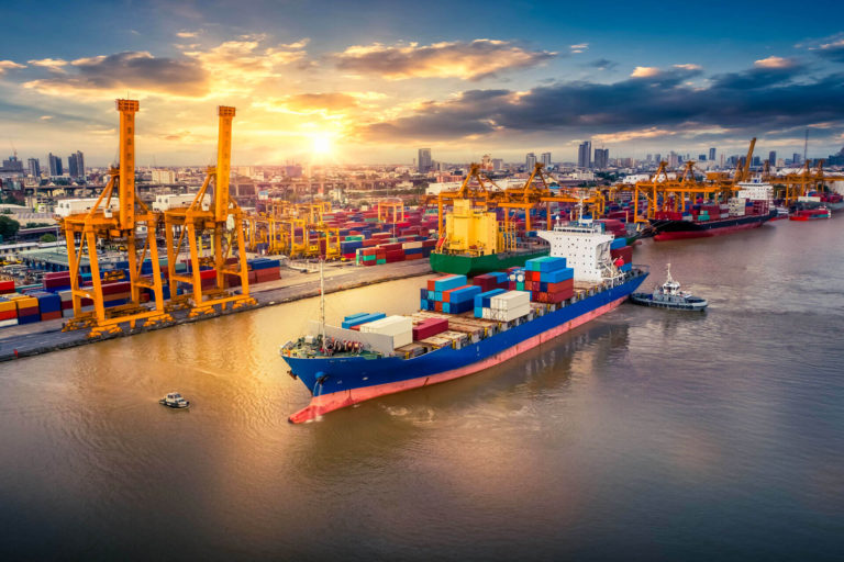 Container ship preparing to dock in port during sunrise