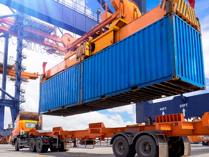 Container being loaded onto a track from a large crane